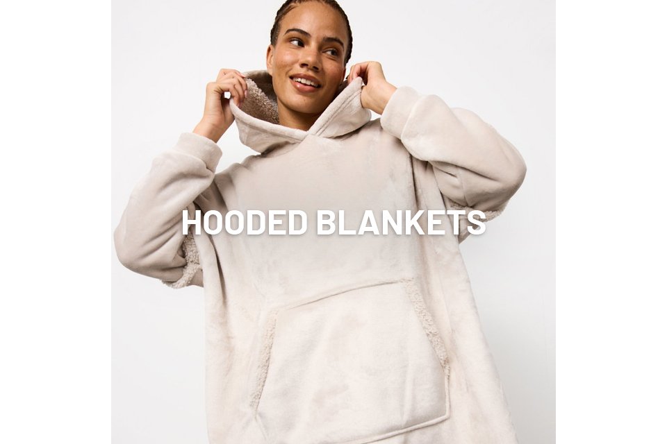 A woman wearing a neutral hooded blanket.