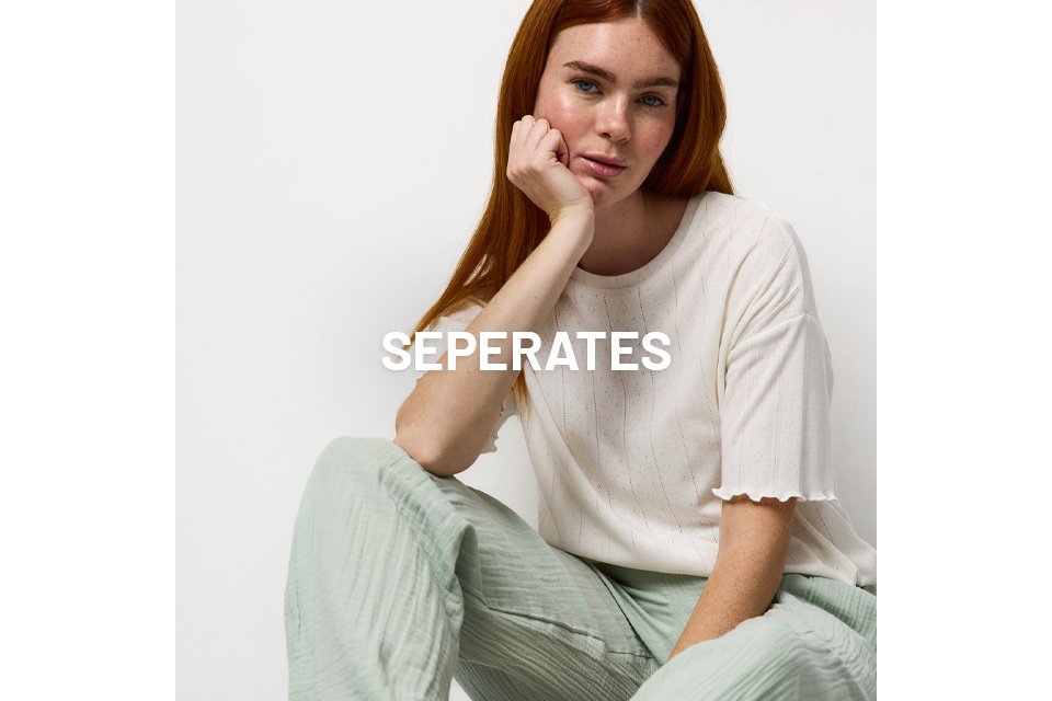 A woman wearing pjs with pale green bottoms and a neutral pyjama top.