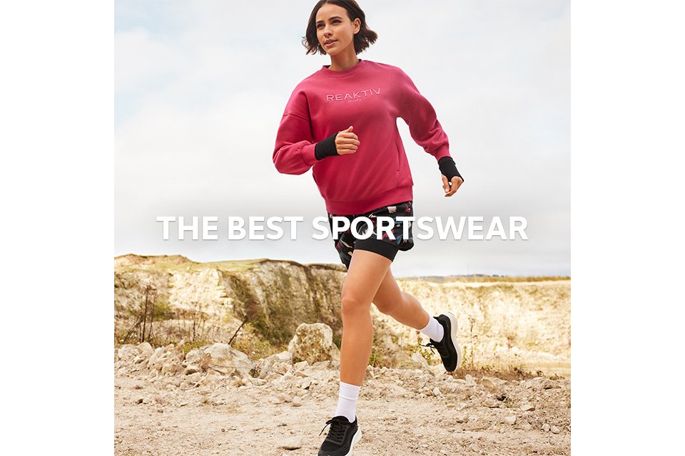 A woman wearing a pink reaktiv jumper and shorts, running outside. 