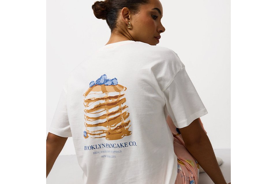 White top with pancake stack illustration and slogan on the back.