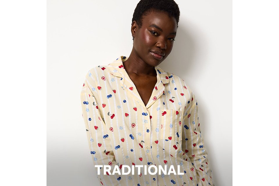 Light-colored button-up pyjama set with small red and blue heart print, styled as traditional nightwear.
