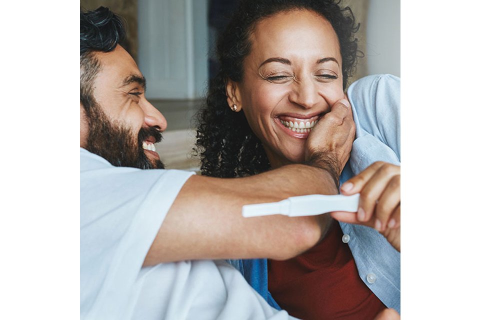 Two children sitting on a light-colored sofa wearing cozy cotton pajamas; one in a blue set with colorful vehicle prints and the other in a pink set with delicate animal patterns, perfect for bedtime comfort.