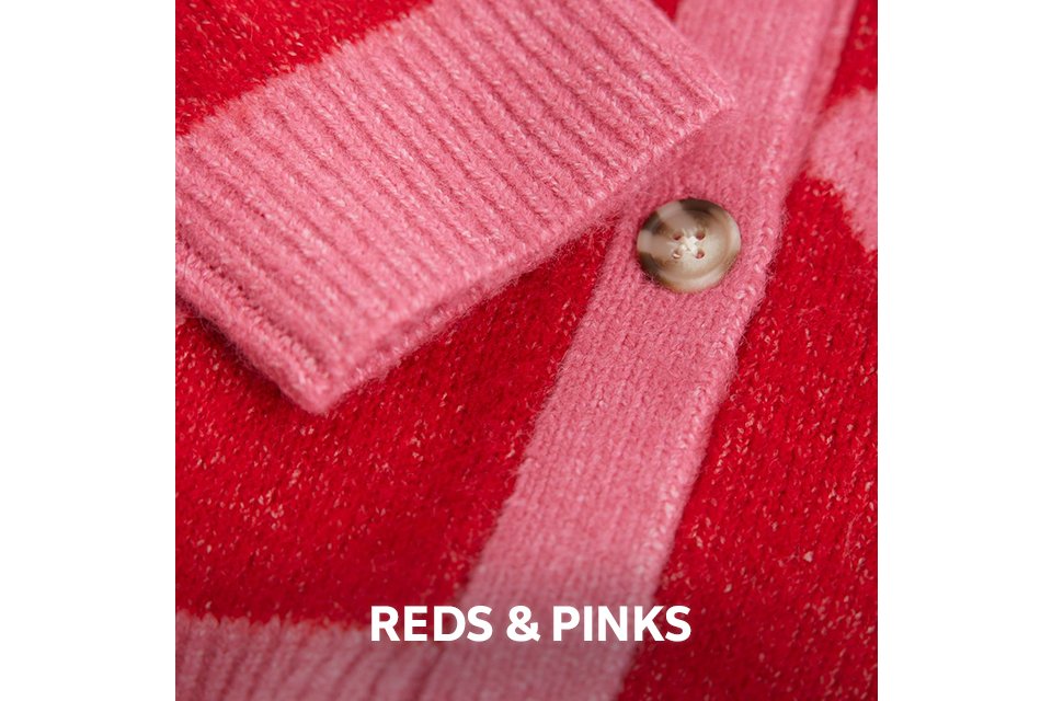 Close-up of soft red and pink knitwear with a button detail.