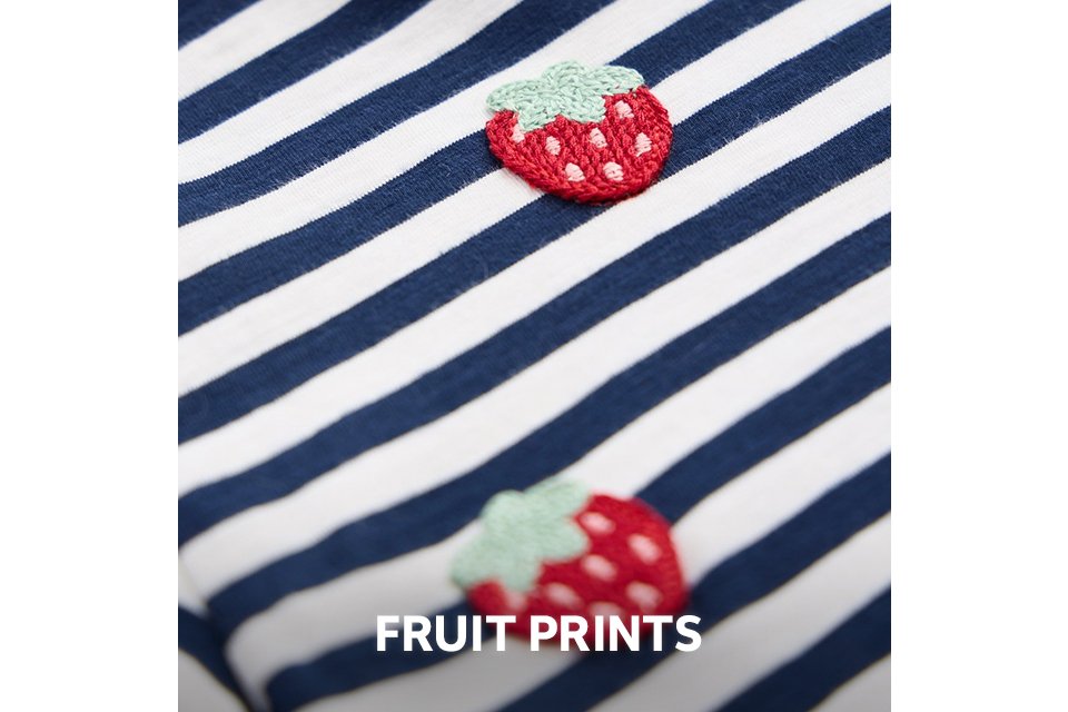 Close-up of a navy and white striped fabric with small embroidered strawberry motifs.