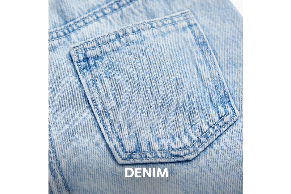 Close-up of light blue denim with visible stitching and a back pocket. 