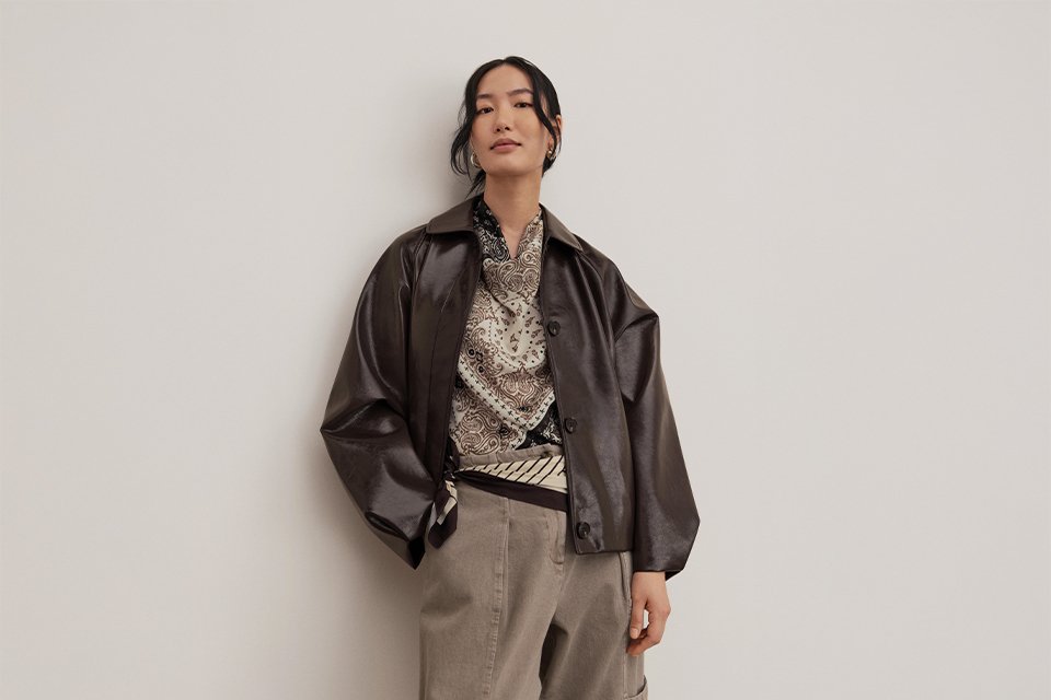 Casual autumn outfits featuring a blue embroidered knit jumper with wide-leg jeans and a beige trench coat layered over red trousers.