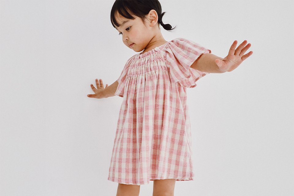  Children’s wedding guest outfit featuring a lightweight pink check dress designed for comfort and smart occasion wear.