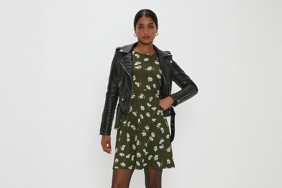  Floral wedding guest dress layered with a black leather jacket for a stylish all-weather wedding outfit.